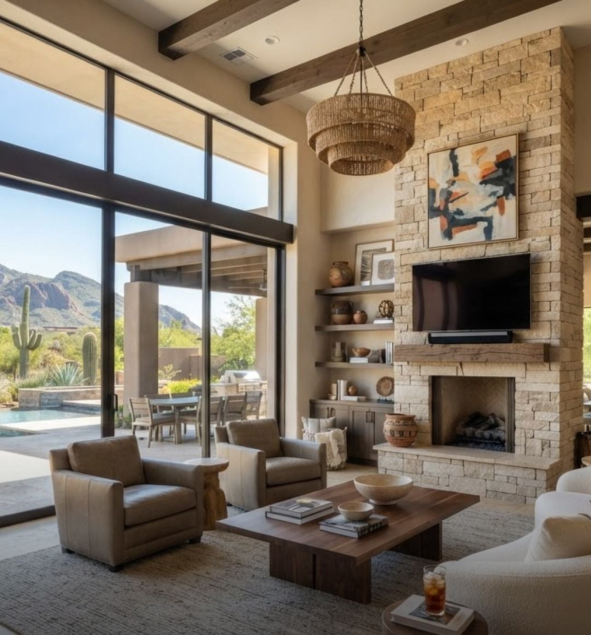 Great room with stone fireplace and desert mountain views